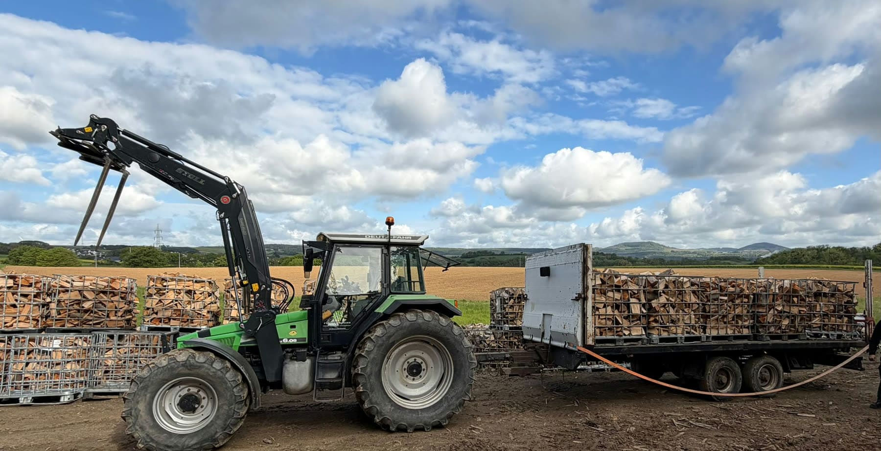 Traktor mit Brennholz-Gitterboxen bei Lohnarbeiten in der Eifel